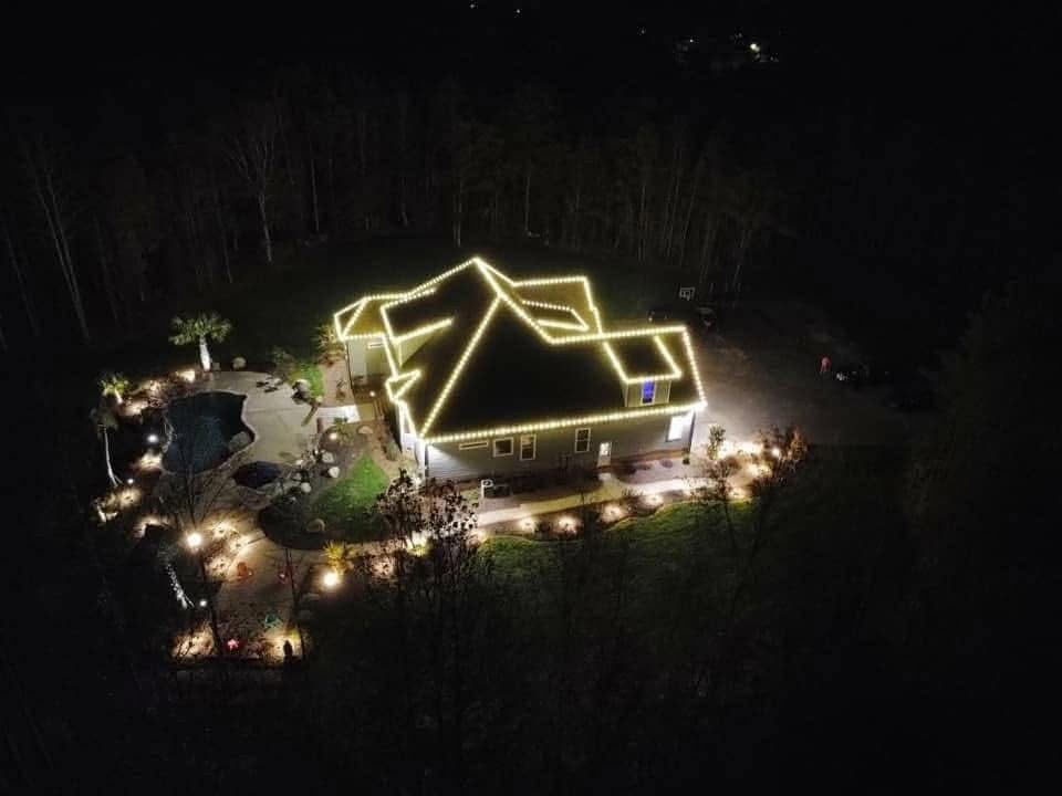 Aerial night photo of a lit roofline on a property lit by Mike’s Cincinnati Christmas Lights