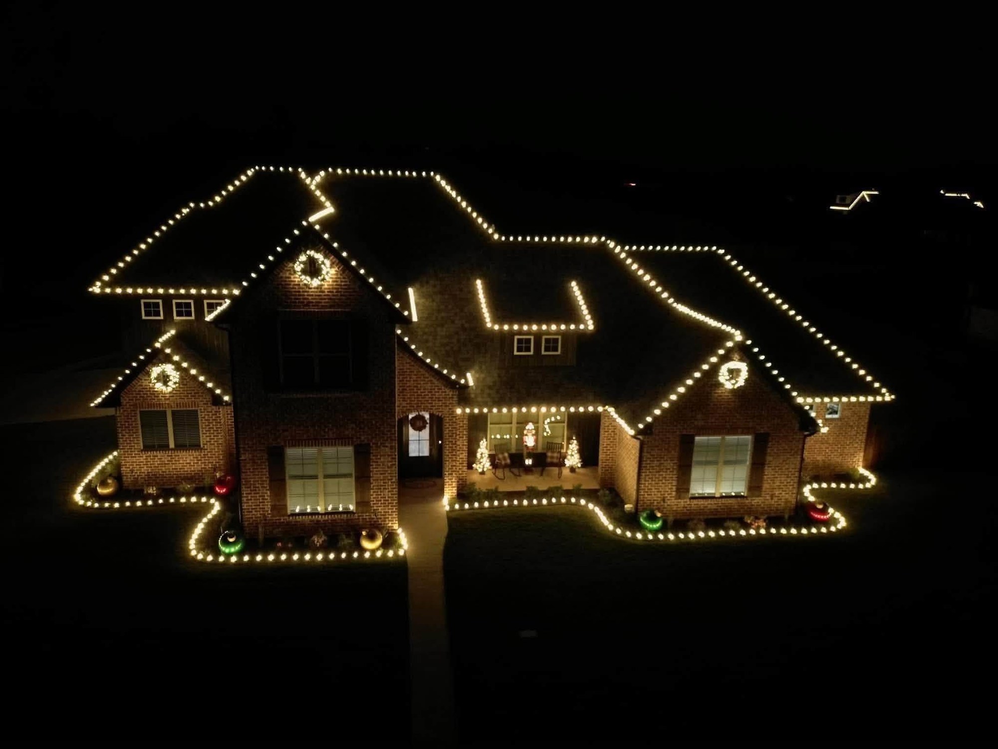 A Cincinnati-area home with its full roofline outlined in warm white Christmas lights at night, installed by Mike&rsquo;s Cincinnati Christmas Lights